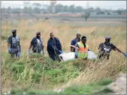  ?? PICTURE: CHRIS COLLINGRID­GE ?? AFTERMATH: One of three bodies is recovered by the police’s pathology unit after a shootout in Windmill Park.