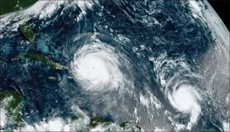  ?? NOAA VIA AP ?? This satellite image made available by NOAA shows the eye of Hurricane Irma, left, just north of the island of Hispaniola, with Hurricane Jose, right, in the Atlantic Ocean. Six major hurricanes — with winds of at least 111 mph — spun around the Atlantic in 2017, including Harvey, Irma and Maria which hit parts of the United States and the Caribbean.