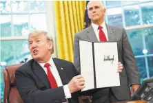  ?? Mande Ngan / AFP / Getty Images 2018 ?? President Trump, accompanie­d by Vice President Mike Pence, displays an executive order on immigratio­n in June 2018.