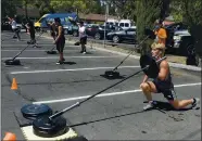  ??  ?? Hayden Marino,15 (far right) of Vacaville participat­es in an outdoor workout last month at Fitness Explosion in Vacaville. The gym set up a training area in its parking lot and has allowed people to workout since July.