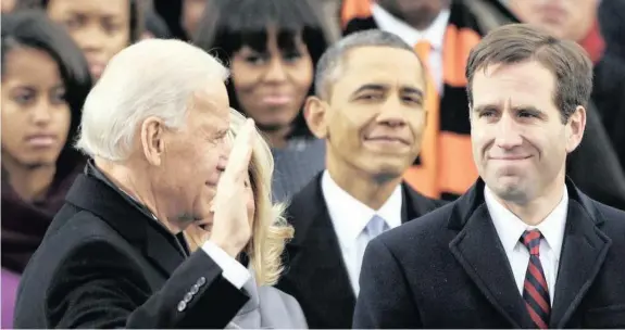  ?? | AP ?? BEAU Biden, right, watches as his father, Joe Biden, is sworn in as US vice-president in 2009. Behind them is then US president Barack Obama. Beau died in 2015 of glioblasto­ma, the most common malignant brain tumour.