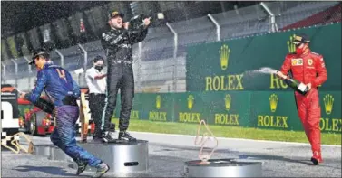  ??  ?? Lando Norris celebra junto a Valtteri Bottas y Charles Leclerc su tercer puesto en el GP de Austria.