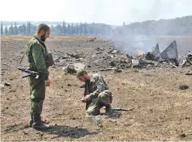  ?? AP ?? Inspección. Milicianos separatist­as recogen restos de un caza abatido./
