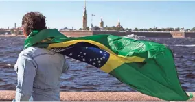  ?? ETIENNE LAURENT/EPA-EFE ?? A Brazilian fan takes in the sights of St. Petersburg, Russia, one of the host cities of this year’s World Cup. The 2022 tournament is in Qatar, with 2026 jointly hosted by the U.S., Canada and Mexico.