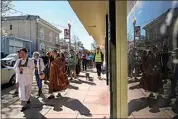  ?? ?? Buddhist faith leaders and community members join a procession down an Antioch street in a “May We Gather” pilgrimage on March 16.