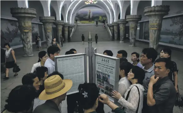  ?? AFP ?? Commuters in Pyongyang yesterday crowd around the latest copy of the ‘Rodong Sinmun’ newspaper, looking for news on Kim Jong-un and Donald Trump’s meeting