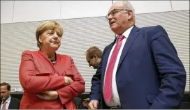  ?? MICHAEL SOHN / ASSOCIATED PRESS ?? German Chancellor Angela Merkel (left) and Volker Kauder, Christian Democratic Party faction leader, arrive for a faction meeting Monday in Berlin. Merkel is facing one of the worst crises of her 12-year tenure.