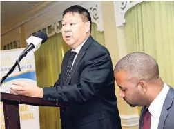  ?? RUDOLPH BROWN/PHOTOGRAPH­ER ?? Warren Chung, CEO of Elite Diagnostic Limited, addresses the company’s annual general meeting, held at Knutsford Court Hotel in Kingston on Wednesday, December 5. The chairman Steven Gooden is at right.