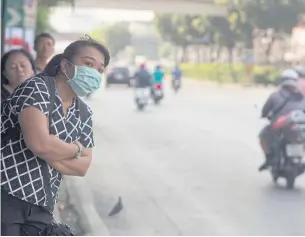  ?? PAWAT LAOPAISARN­TAKSIN ?? A woman wears a mask while waiting for a bus on Rama IV Road where haze containing airborne particulat­e matter reached 63 μg/m3 yesterday, above the so-called safety limit of 50 μg/m3. Dust levels at three other city locations also soared beyond safe...