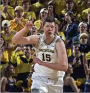  ?? TONY DING — THE ASSOCIATED PRESS ?? Michigan center Jon Teske reacts after making a basket in the first half Jan. 13 in Ann Arbor, Mich.