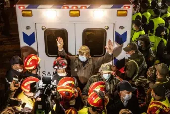  ?? Fadel Senna/AFP via Getty Images ?? A member of the Moroccan security forces gestures to the crowd to move back Saturday as the ambulance carrying the body of 5-year-old Rayan Oram leaves the scene in the remote village of Ighran in the rural northern province of Chefchaoue­n.