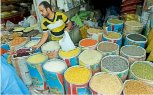  ?? — AFP ?? A Pakistani shopkeeper sells pulses at a market in Lahore. The biggest-ever budget in Pakistani history projects the total outlay of Rs5.10 trillion and resource availabili­ty of Rs4.68 trillion. It indicates external receipts of Rs837.8 billion.