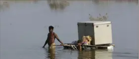  ?? Fareed Khan ?? Villagers retrieve belongings last month in Qambar Shahdadkot, a flood-hit district of Sindh province in Pakistan. At the height of the floods, people used boats on flooded and washed-out roads.