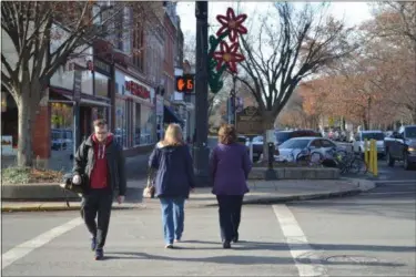  ?? KEITH REYNOLDS — THE MORNING JOURNAL ?? Pedestrian­s mill about downtown Oberlin on Dec. 14. Recent projects by the Lorain County Public Health’s partners in the area have made walking and bicycling easier for the public.