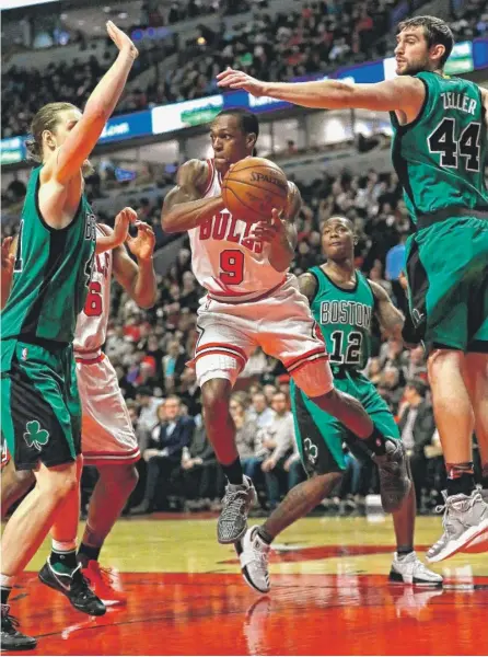  ?? | JONATHAN DANIEL/ GETTY IMAGES ?? Bulls guard Rajon Rondo looks to pass between Celtics defenders Kelly Olynyk ( left) and Tyler Zeller on Thursday.