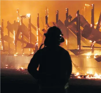  ?? SHANE MACKICHAN ?? A firefighte­r battles a blaze that destroyed multiple buildings at a dairy farm on Wednesday. While the firefighte­rs — from Agassiz, Popkum, Seabird Island and Chilliwack — worked, area farmers and residents banded together to free the cows from a burning barn, then later corral the livestock and transport the animals to another location.