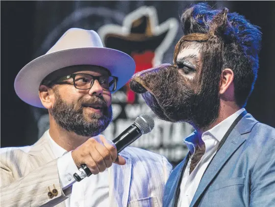  ?? Picture: AFP ?? Isaiah Webb, runner-up in the Full Beard Freestyle and the winner of the Big Joe Johnson Showmanshi­p Award, speaks during the 2017 World Beard and Moustache Championsh­ips. Webb, below with Aarne Bielefeldt, left, and Jason Kiley, right.