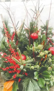  ?? MINTER COUNTRY GARDEN ?? Pots of fresh-cut greens, berries, shrub dogwood stems and pine cones make wonderful and elegant seasonal features for the porch or even inside.