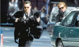  ?? WARNER BROS ?? Robert De Niro and Val Kilmer square off against the LAPD after a bank heist in Michael Mann’s “Heat.”