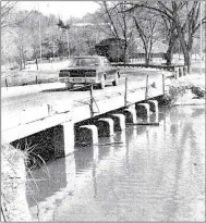  ?? Photo by Kurt Jefferson ?? In this photo, taken in February 1991, we see a vehicle crossing the Lake Bella Vista Dam, which was the primary crossing point connecting the Southeaste­rn side of Bella Vista to U.S. Highway 71.