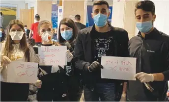  ?? (Courtesy) ?? ISRAELI STUDENTS return from Ukraine, holding signs thanking MK Ahmad Tibi for his role in organizing a flight to evacuate more than 100 Israeli students who were studying abroad, yesterday.