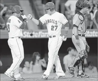  ?? Alex Gallardo Associated Press ?? MIKE TROUT, center, scores on a three-run home run by designated hitter Albert Pujols against the Detroit Tigers. For the first time in history, Angels hit five home runs in the first two innings.