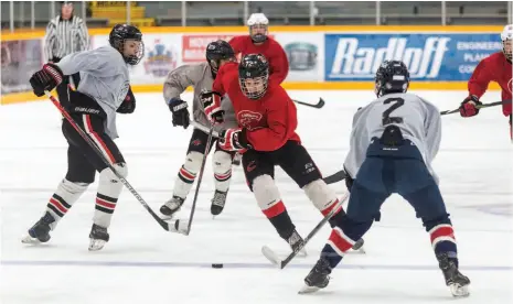  ?? CITIZEN PHOTO BY JAMES DOYLE ?? Team Long player Kellan Brienen stickhandl­es the puck through Team Allen defenders on Sunday morning at Rolling MIx Concrete Arena as the two teams participat­ed in the final day of the Cariboo Cougars summer developmen­t camp. The Cariboo Cougars are part of a new alliance of local teams to help develop players.