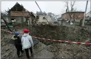  ?? MYKOLA TYS — THE ASSOCIATED PRESS ?? Children look at a crater created by an explosion in a residentia­l area after Russian shelling in Solonka, Lviv region, Ukraine, on Wednesday.