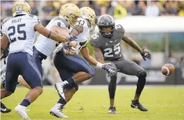  ??  ?? Navy quarterbac­k Zach Abey fumbles in front of Central Florida defensive back Kyle Gibson during a late drive in the first half.