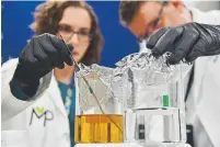  ?? Hyoung Chang,the Denver Post ?? Extraction and research chemist Stefanie Maletich, left, and director of formulatio­n developmen­t Scott Karolchyk of Medpharm check samples for new products at the lab in Denver on Friday.