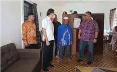  ?? - Gambar NSTP/SITI ROHANA IDRIS ?? ZULKARNAIN (kanan) melihat keadaan rumah yang disumbangk­an syarikat itu kepada Che Aziz (tengah) yang kehilangan rumah dalam kebakaran pada Oktober tahun lalu di Kampung Kubang Palas.