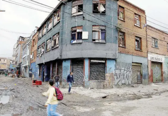  ?? Ansa ?? In città In alto ‘El Bronx' di Bogotà. Sotto: Juan Manuel Santos e venezuali in fuga verso la Colombia