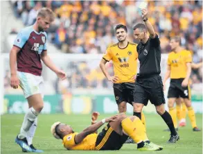  ??  ?? Burnley’s Charlie Taylor (left) is shown a yellow card by Sheldon-born referee Andre Marriner for a foul on Wolves winger Adama Traore at Molineux, September 16, 2018. (Nick Potts/pa Wire)