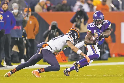  ?? NAM Y. HUH/ASSOCIATED PRESS ?? Vikings running back Dalvin Cook, right, carries the ball as Bears cornerback Teez Tabor comes up for the tackle during the first half of Monday’s game in Chicago. Minnesota, which won 17-9, is still fighting for a playoff berth.