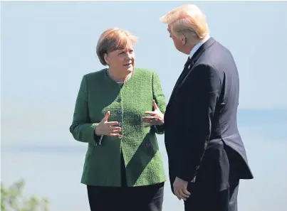  ?? Picture: AP. ?? German Chancellor Angela Merkel talks with US President Donald Trump during the family photo at the G7 summit yesterday in Charlevoix, Canada.