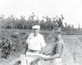  ?? WALT DISNEY CO. ?? In November 1965, Walt Disney, in white, and company executive William Potter inspect the Central Florida property that will become the future home of Walt Disney World.