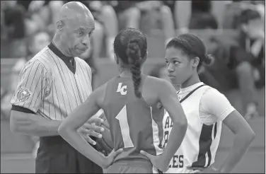  ?? Associated Press ?? Discussion: In this Nov. 12, 2015, file photo, Spenser Simmons, left, a referee with the North Texas Basketball Officials Associatio­n, speaks to players during a high school freshman girls basketball game in Allen, Texas. An Oklahoma man is leading the charge to stamp out the intolerabl­e behavior that referees must endure at every stage of sports, from youth leagues to the adult level. This is an issue we all need to get behind, because there could come a day when no one is willing to officiate the games we play.