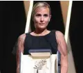  ??  ?? French director Julia Ducournau poses on stage with her trophy after she won the Palme d’Or for her film “Titane”.