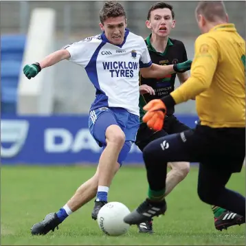  ??  ?? Ciaran McGettigan bears down on the Hollywood goal as Ian Burke comes to block. Photos: Joe Byrne