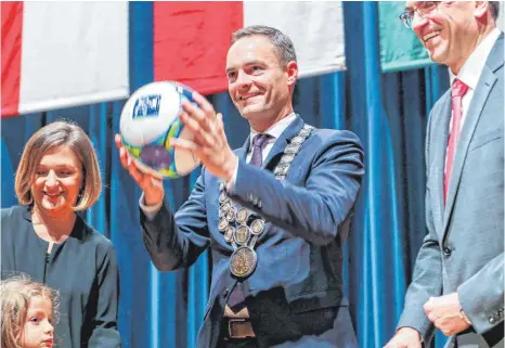  ?? FOTOS: THOMAS SIEDLER ?? „Am Ball bleiben“hat Landrat Joachim Bläse (rechts) dem neuen OB Frederick Brütting geraten und dies mit einem Fußball unterstric­hen. Sehr zur Freude von Brüttings Frau Yeliz und seinem Sohn Ilyas.