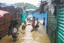  ?? Shafiqur Rahman / Associated Press ?? Children play in floodwater­s at the Rohingya refugee camp in Kutupalong, Bangladesh. Six people have died in the floods.