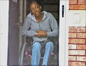  ?? Lake Fong/Post-Gazette ?? Tionna Highsmith, then 15, looks through a screen door at her grandmothe­r's house on June 27, 2006, nearly a year after being partially paralyzed in a drive-by shooting.