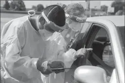  ?? NEWS-SENTINEL PHOTOGRAPH­S BY BEA AHBECK ?? Above: Carbon Health medical assistant Hector Loya and Adventist Health Lodi Memorial registered nurse Cathleen Myers prepare to test Gloria Gallegos during a free COVID-19 testing event at the First Baptist Church parking lot in Lodi on Aug. 14. Below: Foam swabs wait to be used during the event.