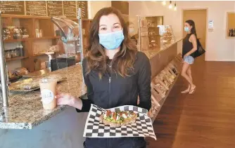  ??  ?? Off the Trail, offering acai bowls, smoothies, artisan toast and more, opened Monday at 650 Main St. in Hellertown. Owner Allison Guido poses with a mango banana smoothie and “The Favorite” toast, featuring avocado, tomato, burrata, basil and balsamic drizzle.
