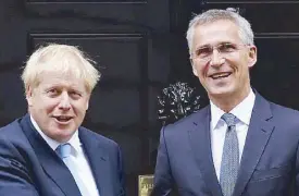  ?? AP ?? British Prime Minister Boris Johnson poses for the media as he greets NATO Secretary General Jens Stoltenber­g before their meeting at 10 Downing Street in London on Tuesday.