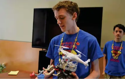  ?? (Photo by Charlie Benton, SDN) ?? Eighth-grader Dylan Folds shows off his team’s prototype robot at Camgian Microsyste­ms. Three robotics teams from Armstrong Middle School visited the firm’s offices to present their ideas to Camgian software engineers.