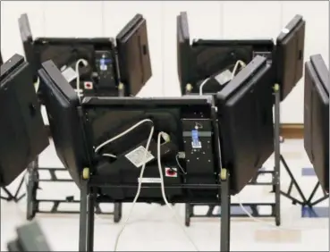  ?? JOHN MINCHILLO — THE ASSOCIATED PRESS FILE ?? Electronic voting machines in a polling station.