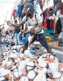  ??  ?? A slippers vendor tries to get a sale.