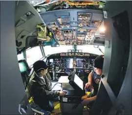  ?? Ted S. Warren Associated Press ?? FEDERAL regulators ordered the grounding of the 737 Max 8 and 737 Max 9 on Wednesday. Above, workers make adjustment­s in the cockpit of a 737 in 2015.