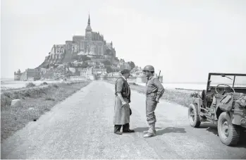  ?? ARCHIVES ASSOCIATED PRESS ?? Un soldat américain et un civil français parlant sur la chaussée menant au Mont ont Saint-Michel en Normandie le 8 août 1944.